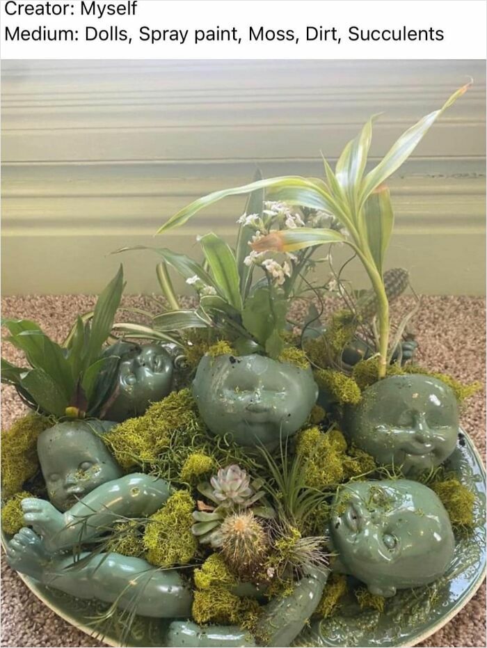 DIY project with green spray-painted doll parts, moss, and succulents in a decorative arrangement.