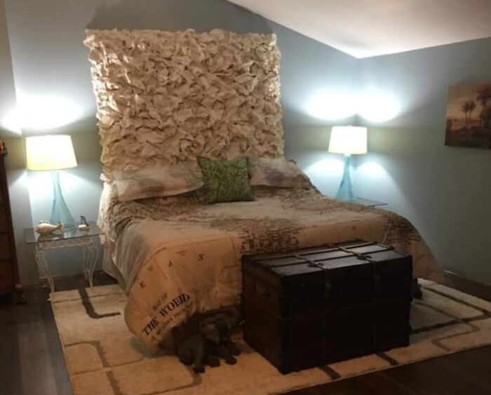 DIY project with a textured headboard above a bed in a modern bedroom, featuring lamps and a vintage trunk at the foot.