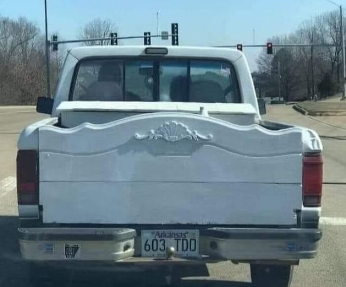 DIY craft shaming: Pickup truck with a white, ornate wooden tailgate at a traffic light.