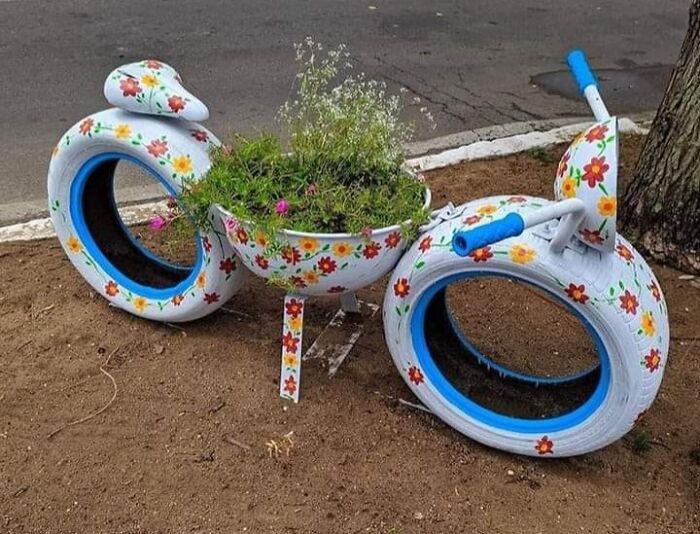DIY project with painted tire and basin flower planter shaped like a motorcycle.