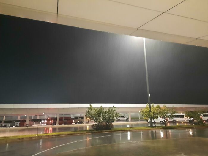 Night view of a deserted parking lot under heavy rain, reflecting the mood of cancelled reservations.
