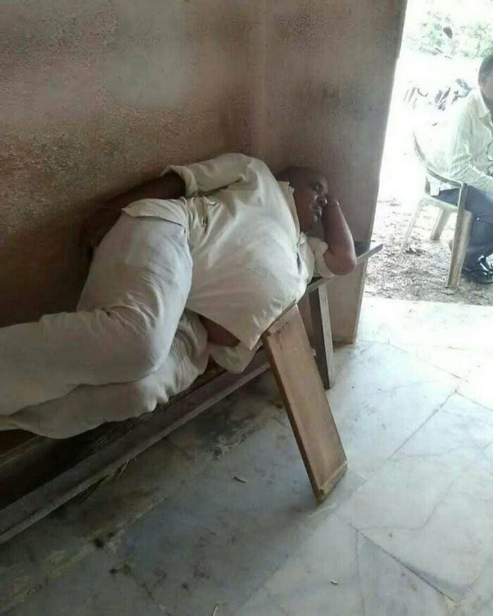 Hombre durmiendo en banco con posición incómoda que provoca risas, imagen graciosa que va fuerte y genera diversión.