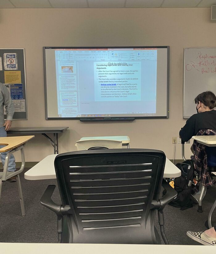 Classroom with a presentation on the screen, student seated, related to infuriating teachers.