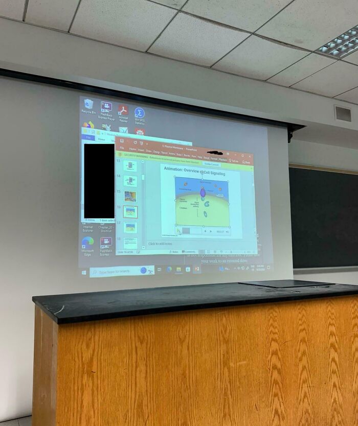 Presentación proyectada en aula vacía, resaltando la falta de profesionalidad docente.