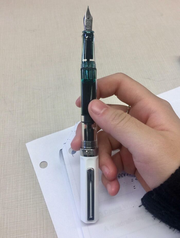 Mano sosteniendo una pluma estilográfica, representando toxicidad en la enseñanza por falta de profesionalidad.