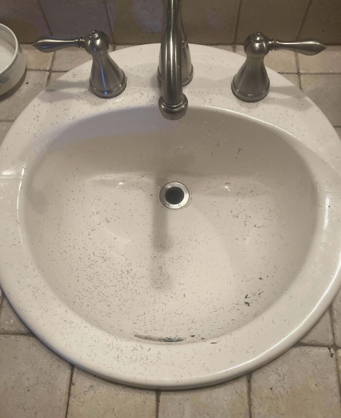 Bathroom sink with hair trimmings left behind, reflecting annoying boyfriends or husbands' habits.