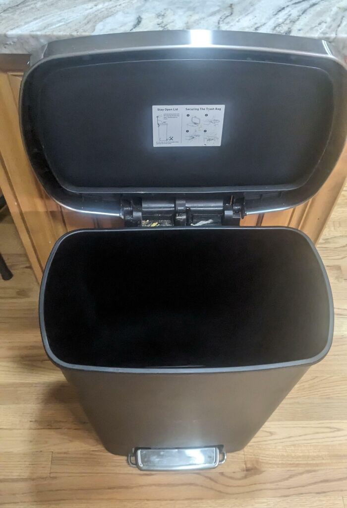 Empty trash can with lid open, showcasing forgotten chore by annoying boyfriends and husbands.