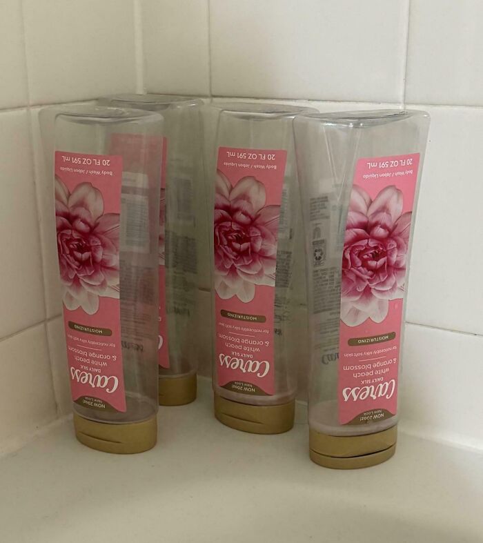 Upside-down body wash bottles on a shower ledge, highlighting typical habits of annoying boyfriends or husbands.