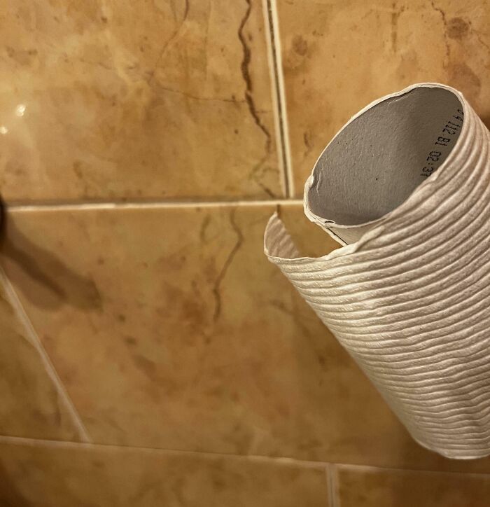 Empty toilet paper roll on a bathroom wall; a common misstep often attributed to annoying boyfriends and husbands.