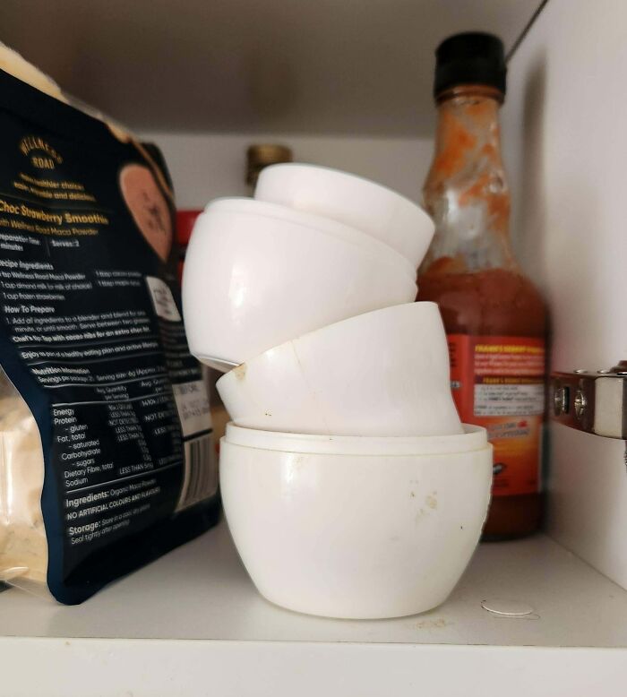 Stacked measuring cups in a kitchen cabinet, possibly related to annoying boyfriends or husbands.