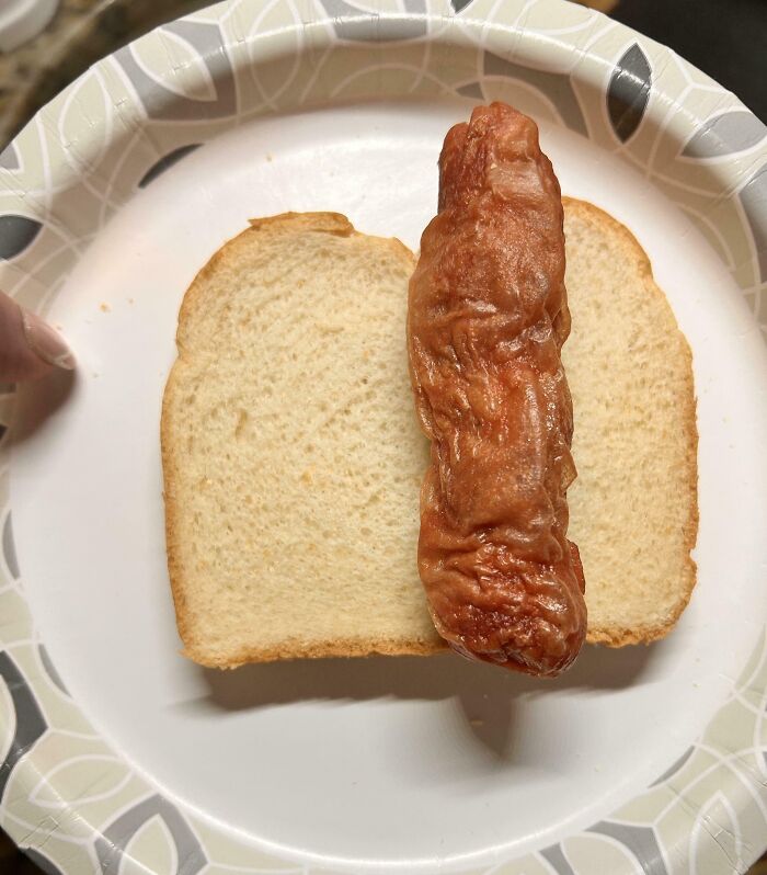 A slice of white bread with an unappetizing sausage on a plate, humorously depicting annoying boyfriends' husbands' pranks.