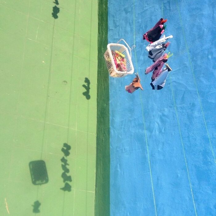 Clothesline with shadows on colored surface, artistically captured by Jose Ruiz González, highlighting the extraordinary in the ordinary.