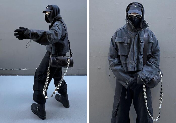 Fashion risks: Person in full black outfit with mask, oversized jacket, silver chain, and accessories.