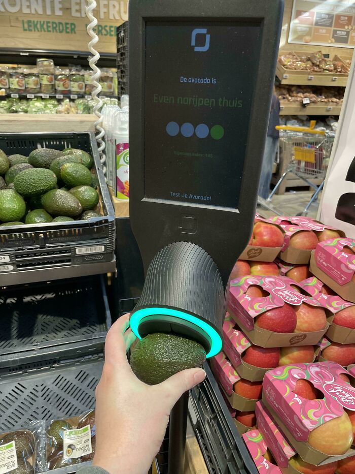 Person using an avocado ripeness checker at a supermarket, showcasing tourist-interesting-experiences.
