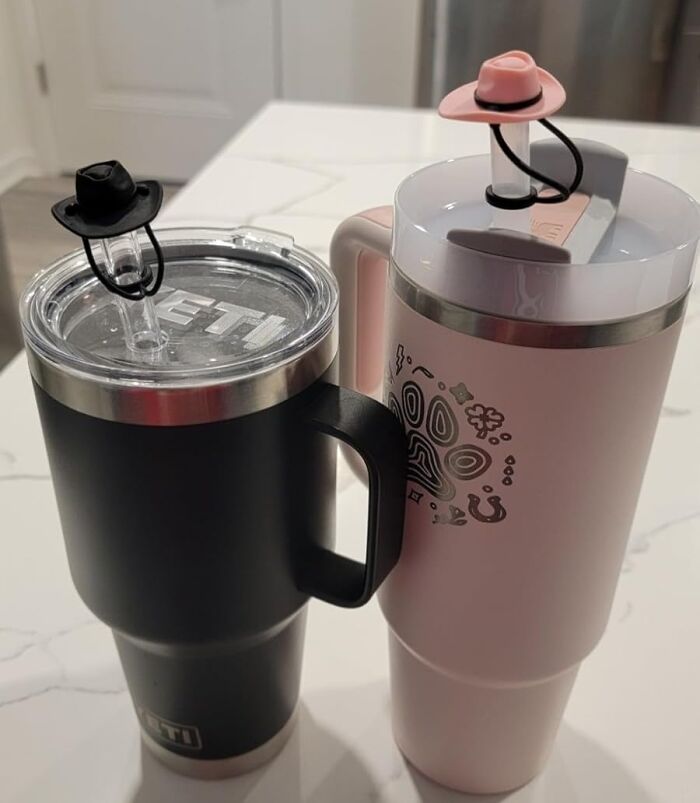 Two travel mugs with cowboy hat straw toppers, showcasing random things that catch attention.