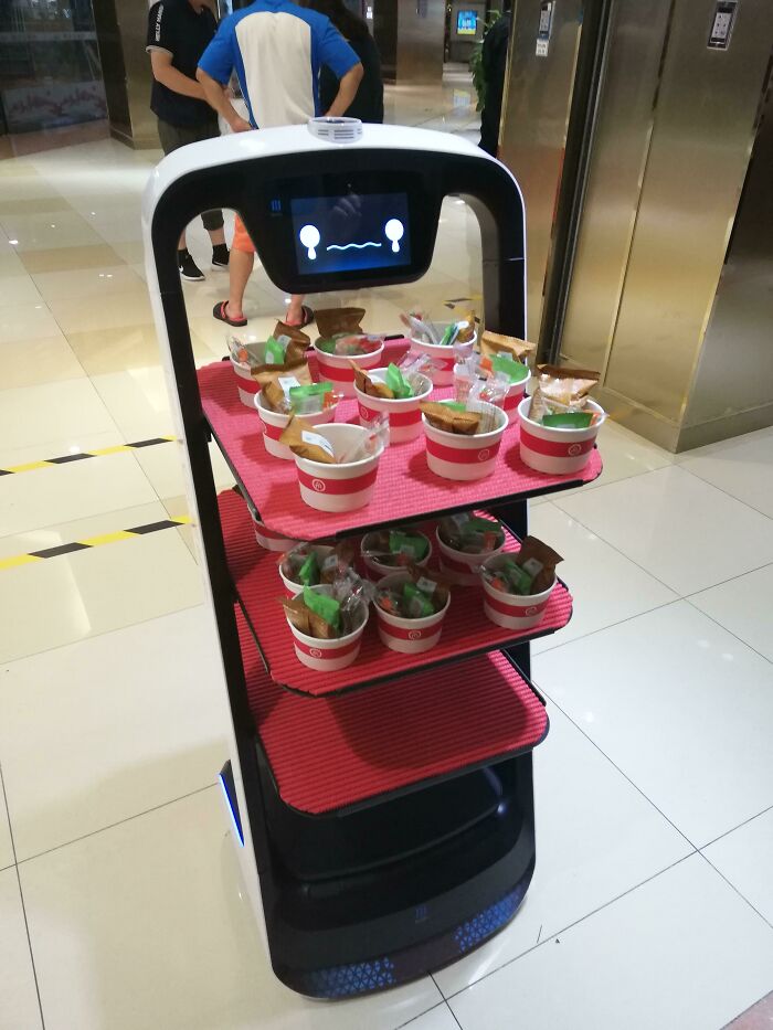 Robot serving snacks in a hotel lobby, showcasing tourist-interesting-experiences with automated service.