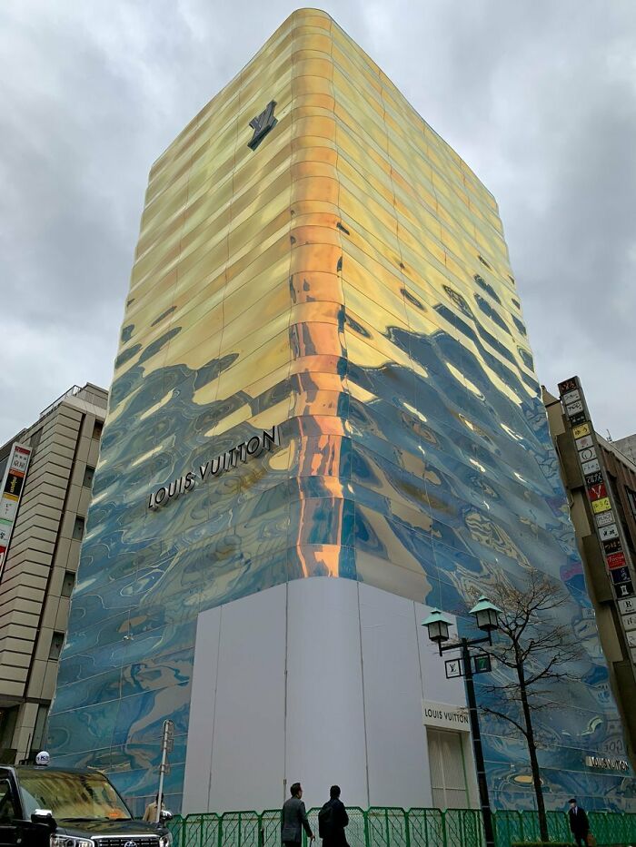 Louis Vuitton store with reflective facade, a tourist-interesting experience in urban architecture.