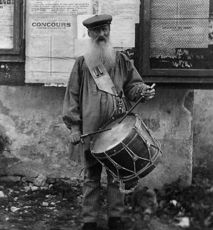 Man dressed in historical attire holding a drum, representing outdated jobs.