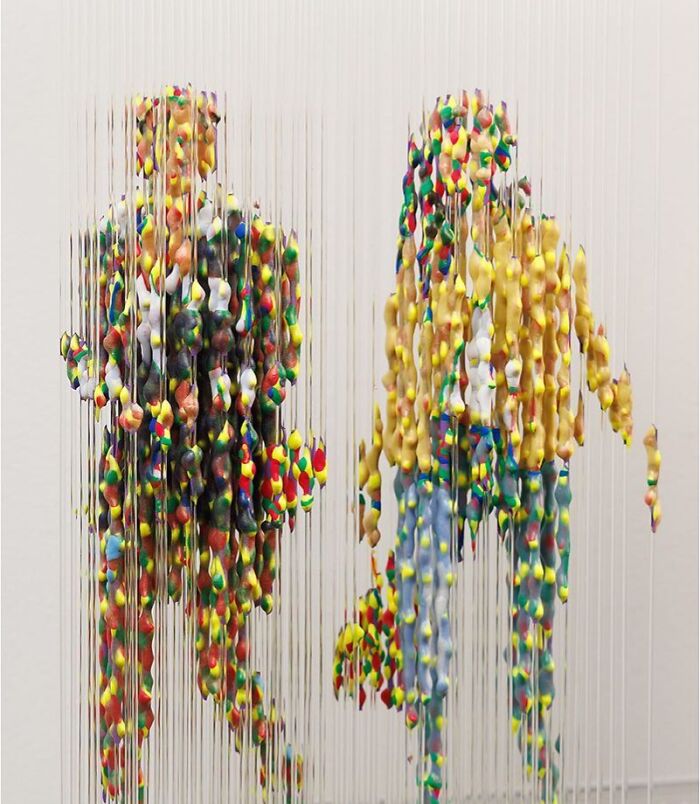 Fragmented three-dimensional painting of two colorful figures by Chris Dorosz, featuring suspended paint droplets.