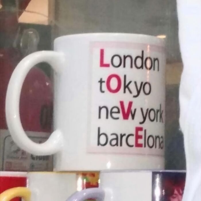 Mug design fail with city names forming the word "LOVE" in red letters.