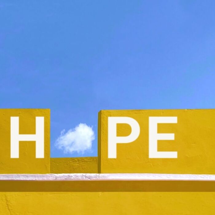 A cloud forms the "O" in "HOPE" against a yellow wall, captured by Jose Ruiz González.