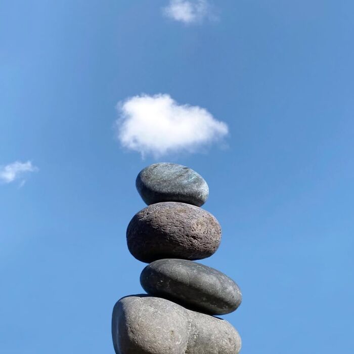 Stacked stones under a small cloud, showcasing extraordinary within the ordinary.