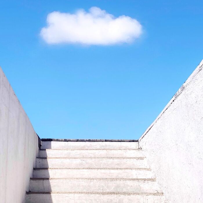 Concrete stairs leading to a vibrant blue sky with a single cloud, captured by José Ruiz González.