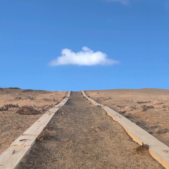 Pathway leading up to a solitary cloud in the sky, captured by Jose Ruiz González.