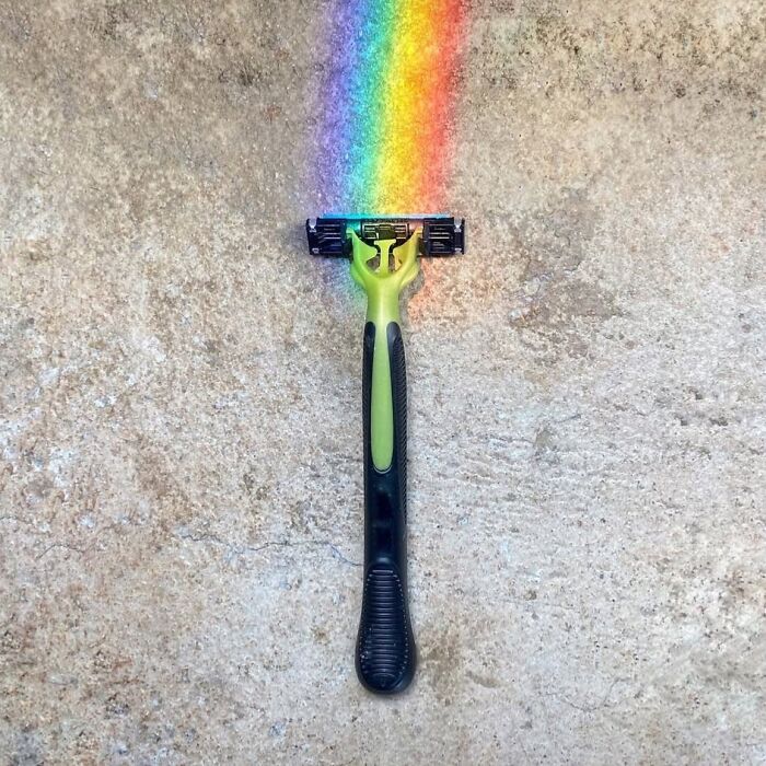 Razor on concrete, reflecting a rainbow, showcasing extraordinary within the ordinary.