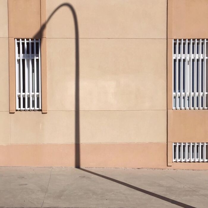 Jose Ruiz González captures a unique shadow of a streetlamp on a building wall with barred windows.