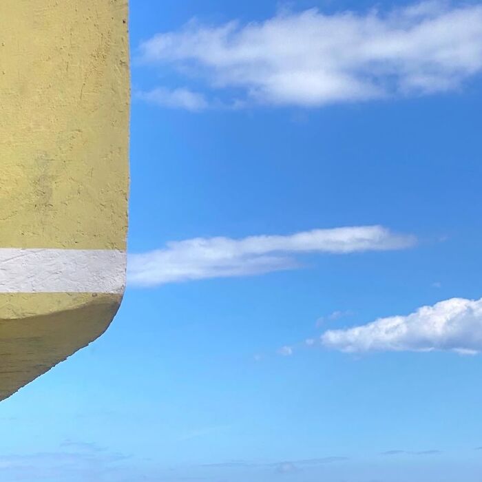 Yellow architectural detail against a bright blue sky, captured by Jose Ruiz González.