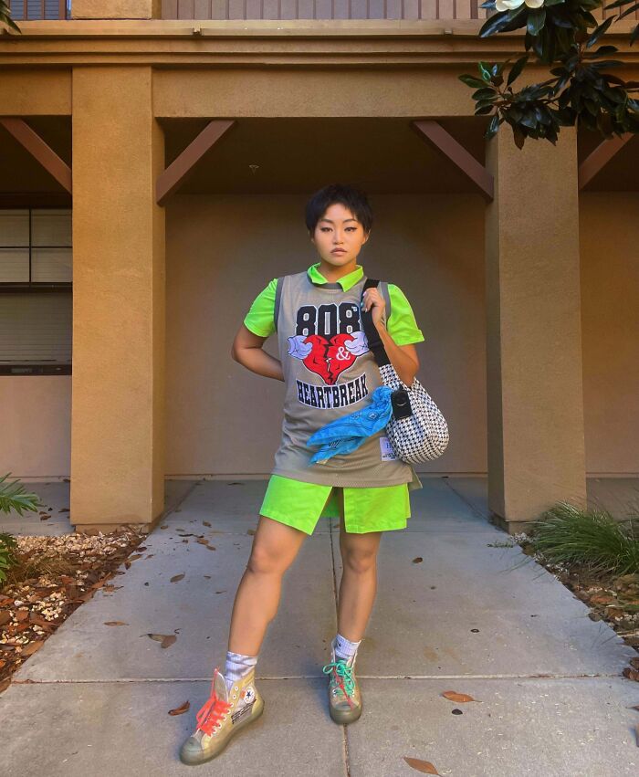 Person confidently showcasing unique fashion with neon green outfit and graphic shirt, embodying fashion risks.