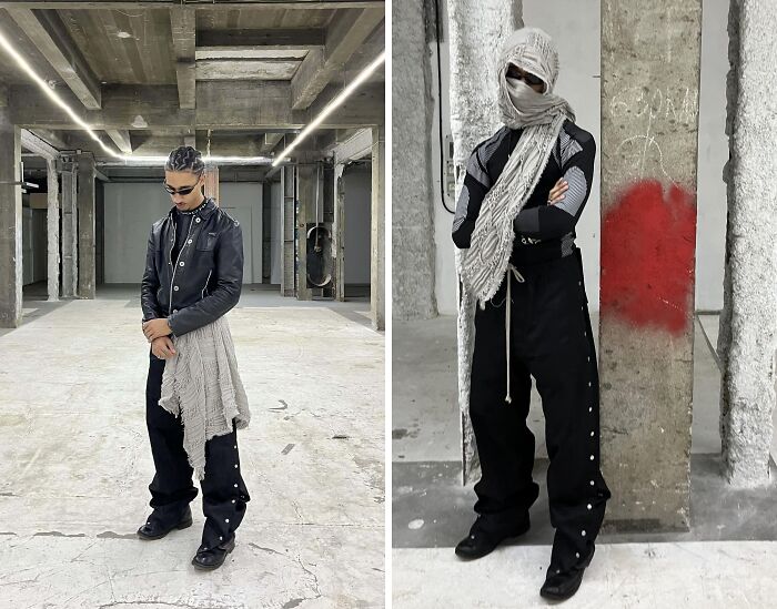 Person wearing edgy fashion in a concrete setting, with bold black clothing and a long scarf, epitomizing fashion risks.