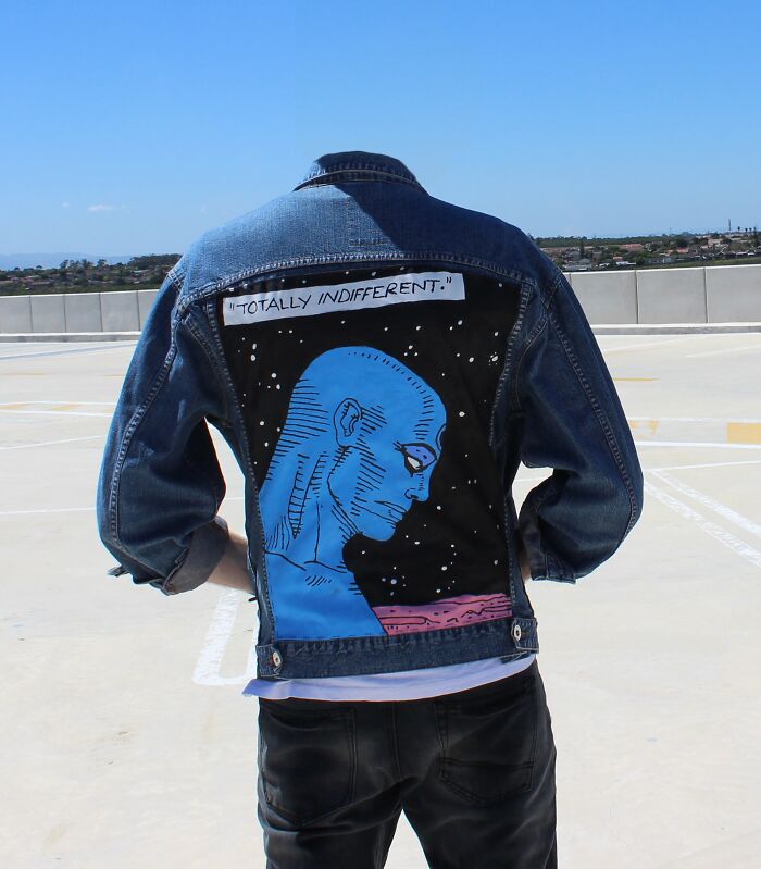 Fashion risks: A person wearing a denim jacket with a bold blue graphic design on the back, reading "Totally Indifferent."