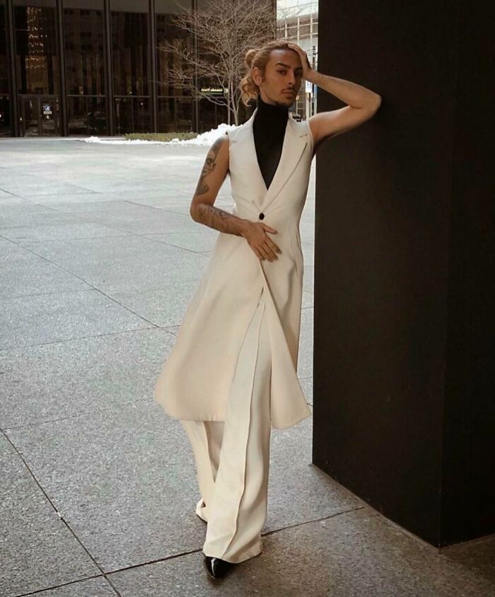 Person in a stylish white outfit and black turtleneck, posing confidently, highlighting bold fashion risks.