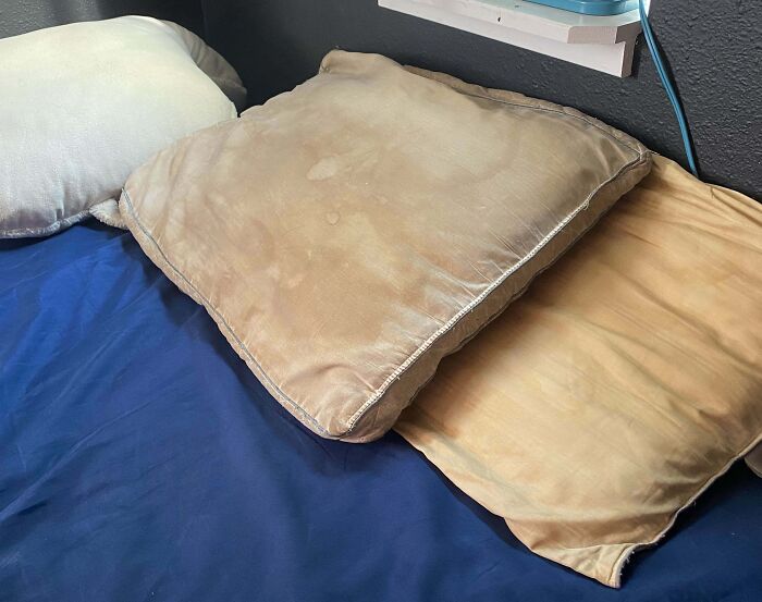 Stained pillows on bed, possibly due to annoying boyfriends or husbands neglecting cleanliness.