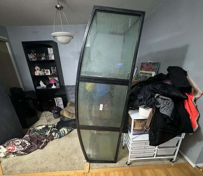 A large, tilted cabinet awkwardly placed in a cluttered room, hinting at annoying boyfriends or husbands' habits.