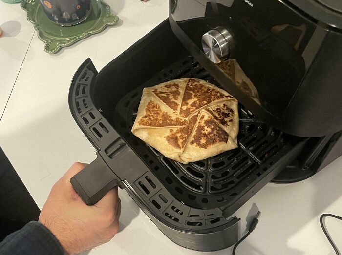 Annoying boyfriends or husbands using an air fryer to make a crispy quesadilla for a quick snack.