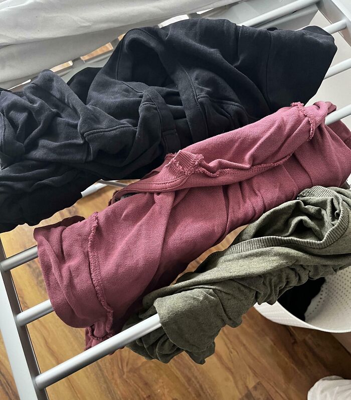 Clothes hung haphazardly on a drying rack, possibly left by annoying boyfriends or husbands.