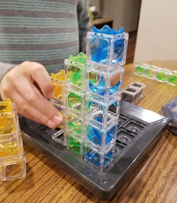 Child building colorful tower game, perfect gift idea for fun aunts and uncles.