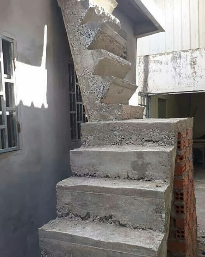 Concrete staircase with poor design displaying architecture fail, leading to an obstructed roof.