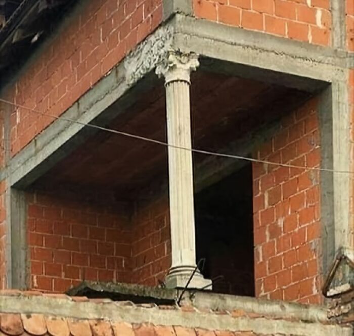 Column awkwardly placed in brick building corner, illustrating architecture fail.