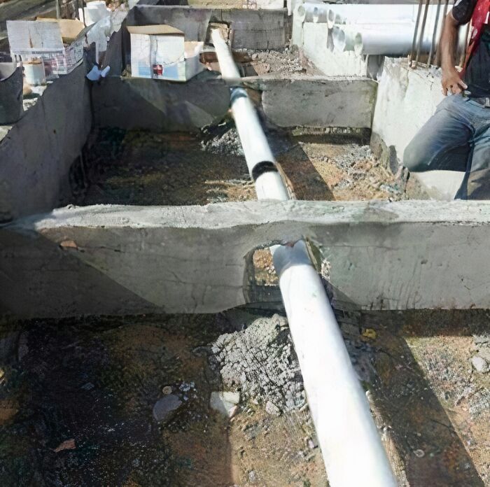 A pipe running through a concrete wall, illustrating an architecture fail.