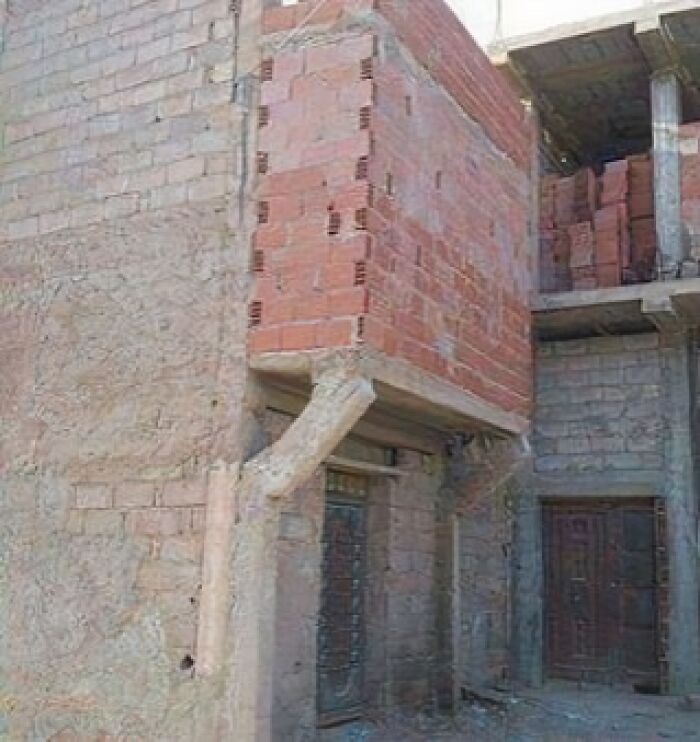 Architecture fail featuring a precariously supported brick structure with mismatched alignment and poor design e*******n.