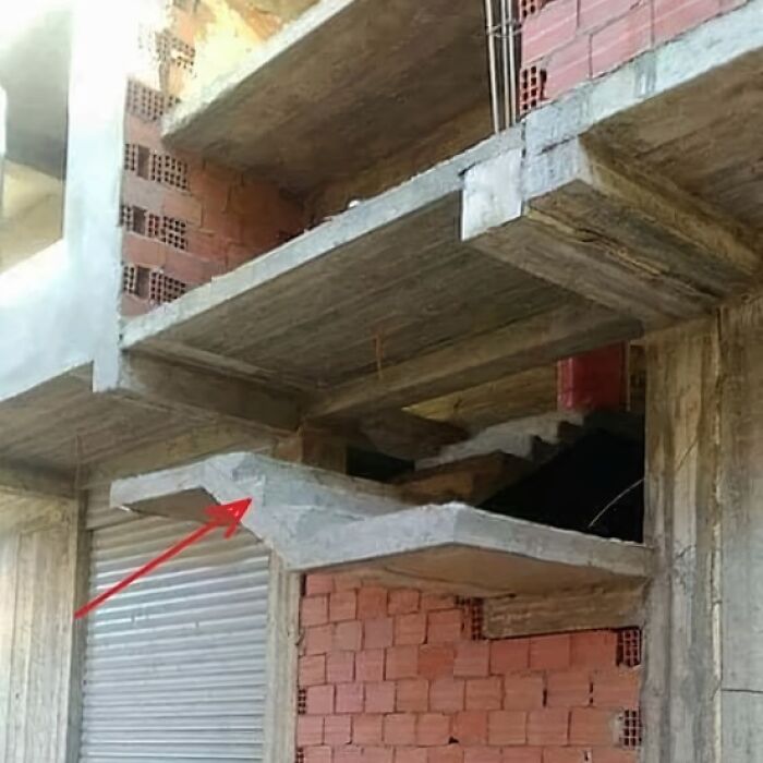 Incomplete staircase in a building, showcasing an architecture fail with missing steps and a red arrow pointing.