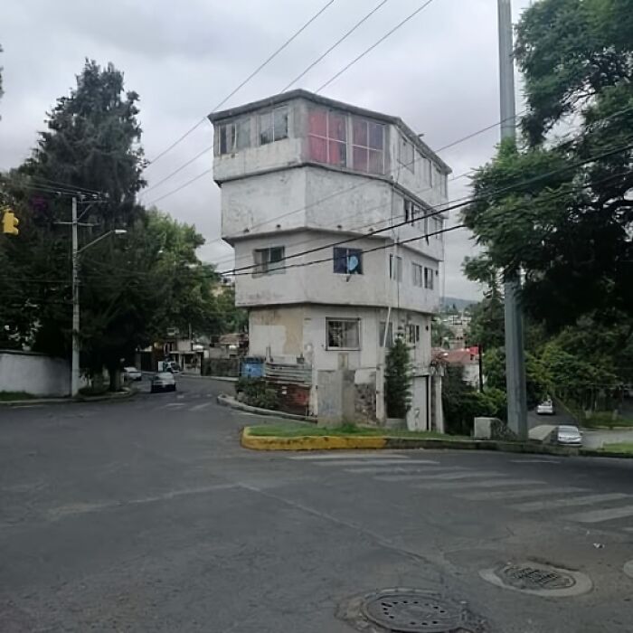 Unstable multi-story building on a narrow street corner, illustrating architecture fails.