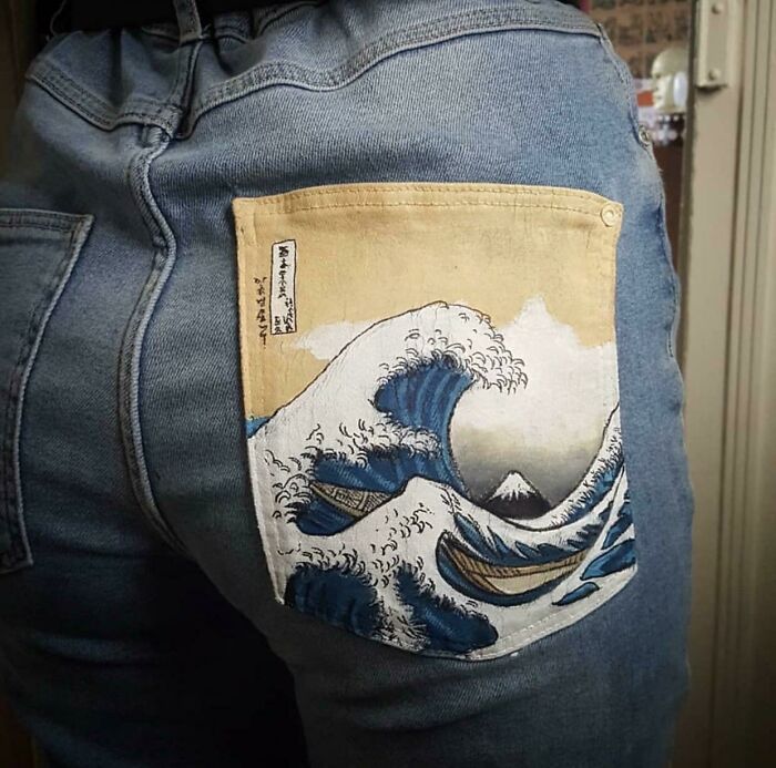 Denim jeans featuring a pocket with a painted wave design as a fashion risk.