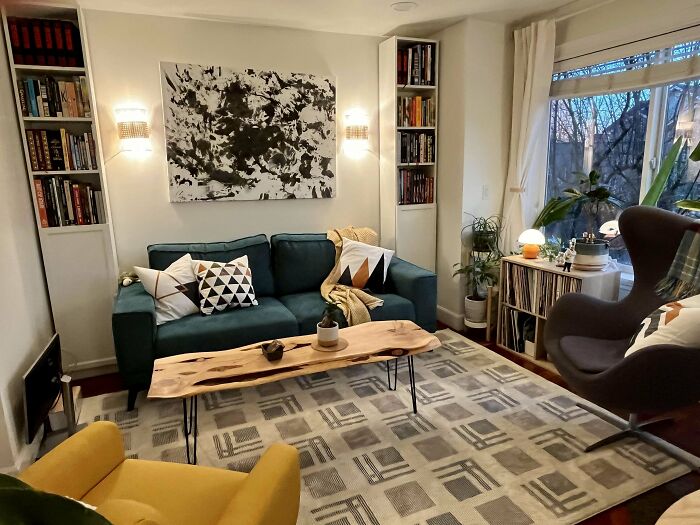 Cozy living room in a beautifully decorated home featuring modern art, patterned pillows, and natural wood accents.