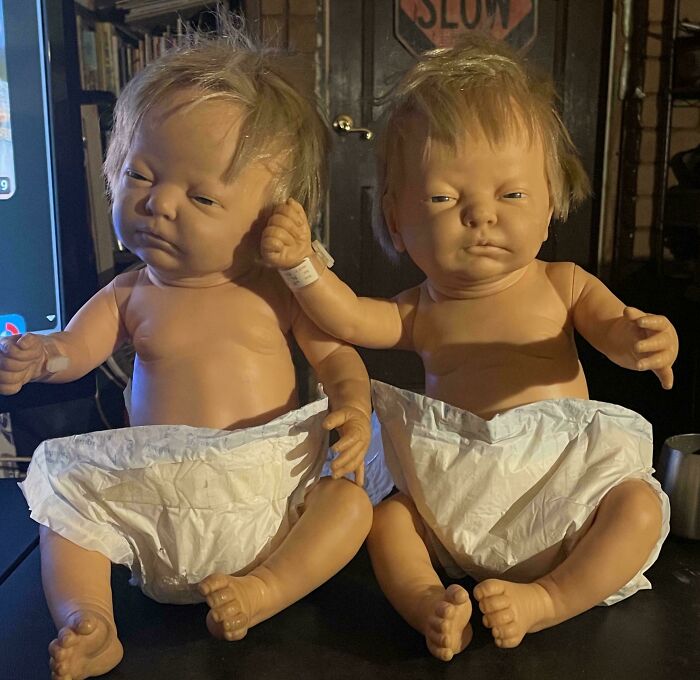 Two vintage baby dolls wearing diapers, sitting side by side, evoking nostalgic childhood memories.