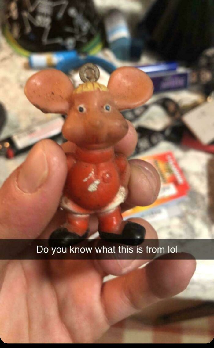 Vintage toys: A person holds a nostalgic small mouse figurine in hand, evoking childhood memories.